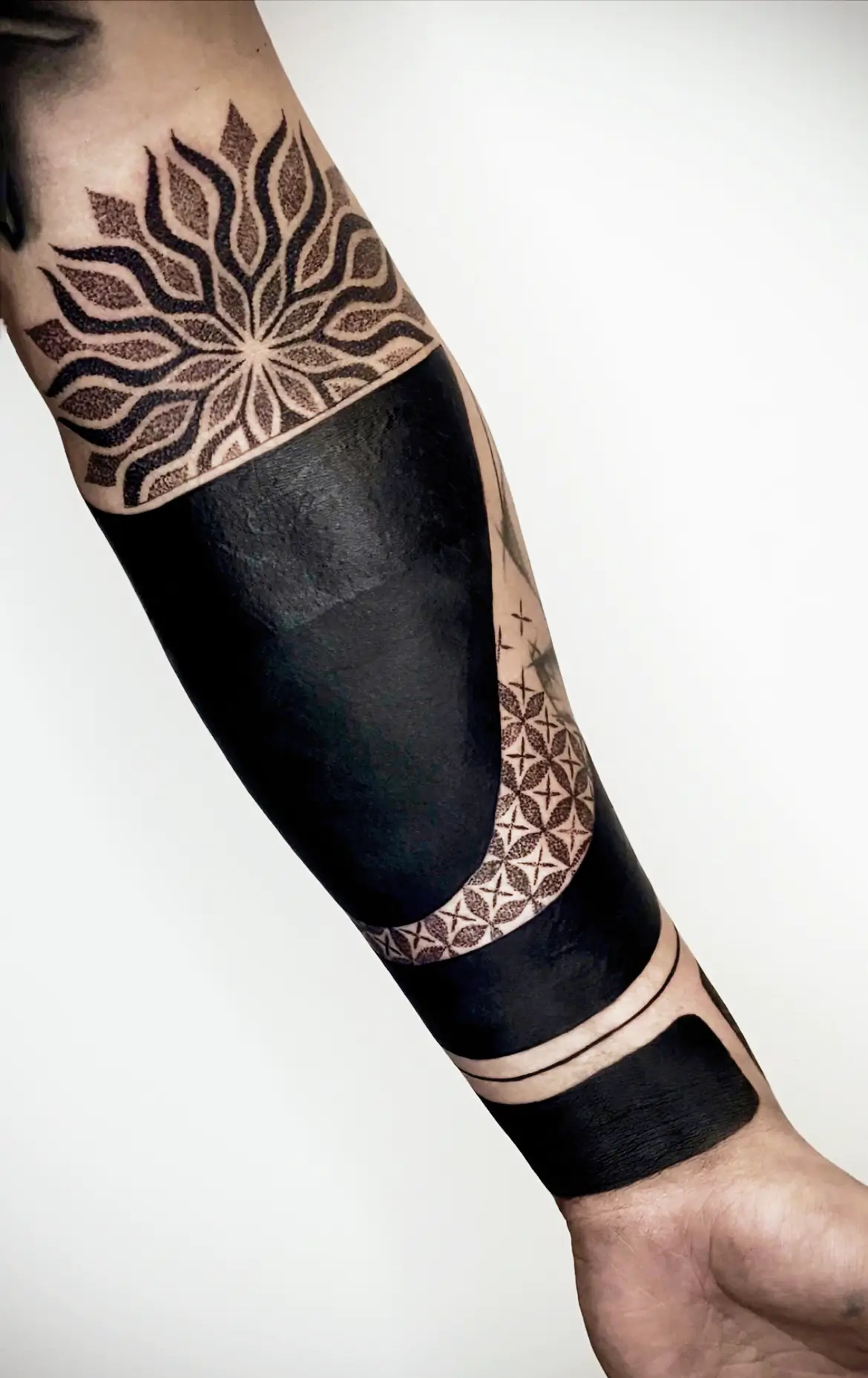 black full sleeve blackout tattoo with mandala motive